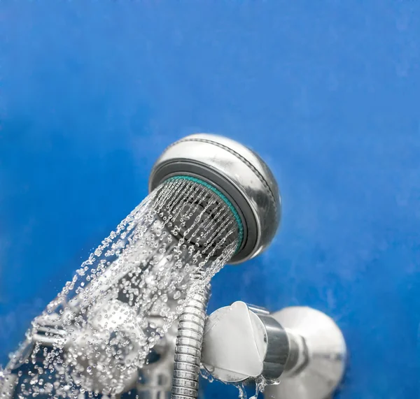 Pomme de douche dans le bain sur bleu — Photo