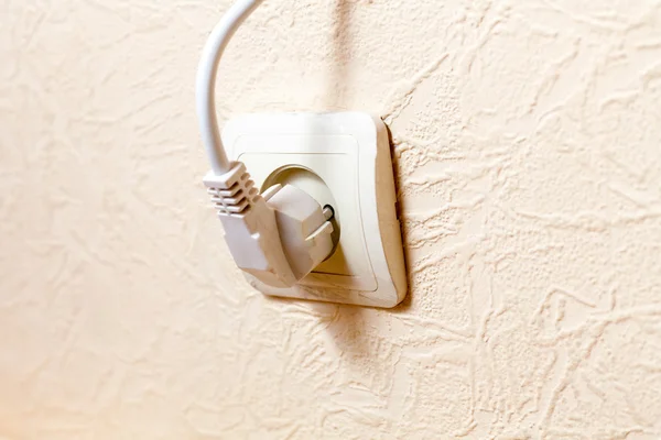 Elektrischer Stecker an einer beigen Wand — Stockfoto
