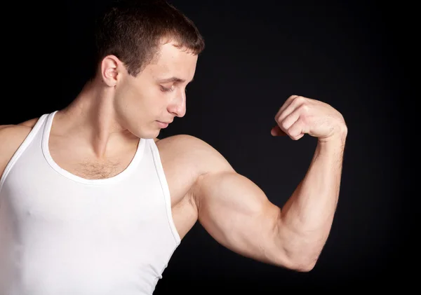 Strong bodybuilder posing on black background — Stock Photo, Image