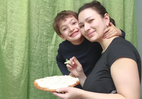 Lächelnde Mutter und ihr Sohn haben Spaß in der Küche — Stockfoto