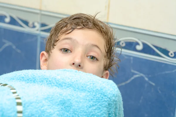 Pojke med en filt handduk i händerna framför huvudet — Stockfoto