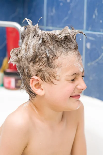 Leende liten pojke täckt med såpbubblor — Stockfoto