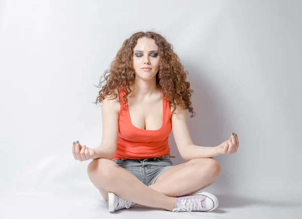 Vista di giovane donna fare meditazione yoga su uno sfondo bianco con gli occhi chiusi — Foto Stock