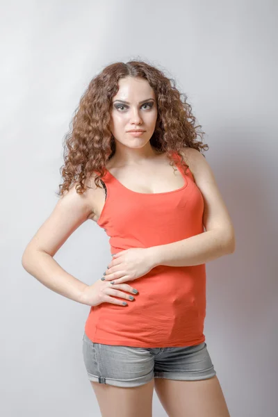 Curly brunette on white background red shirt — Stock Photo, Image