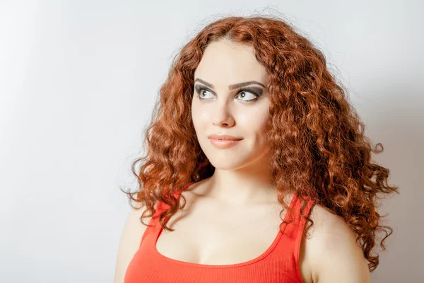 Curly brunette on white background red shirt — Stock Photo, Image