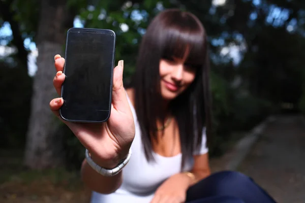 Smiling teenage girl shows cell — Stock Photo, Image