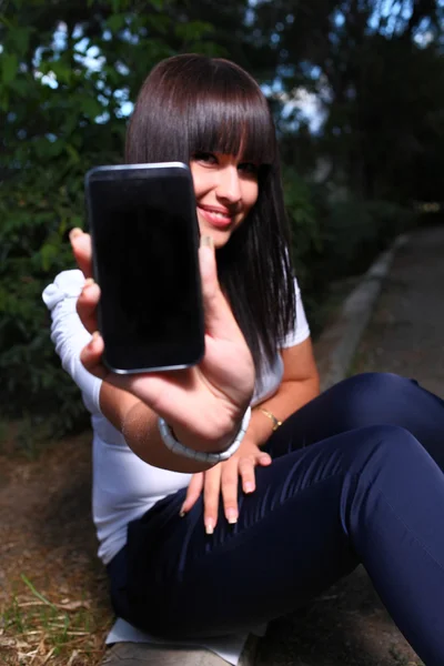Smiling teenage girl shows cell — Stock Photo, Image