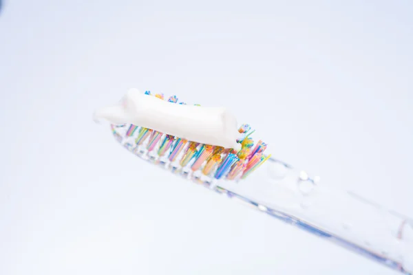 Tandenborstel met tand plakken op — Stockfoto