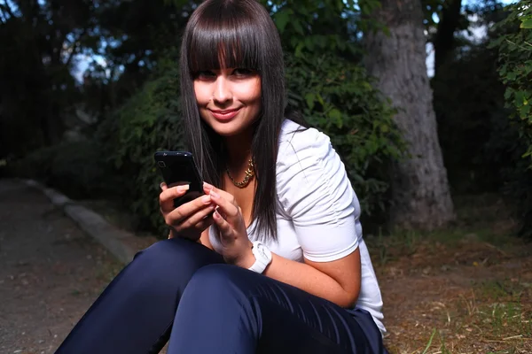 Sonriente adolescente muestra celular — Foto de Stock