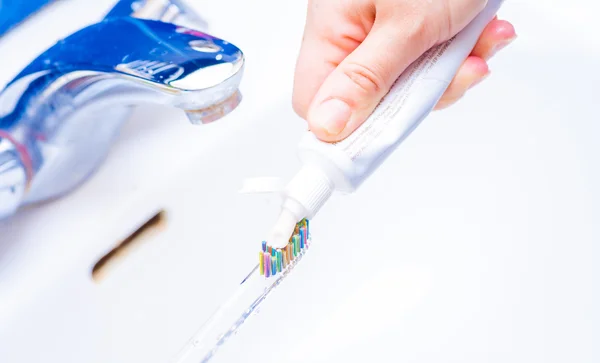 Presser le dentifrice sur la brosse à dents — Photo