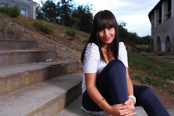 Güzel bir genç kadın outdoors eski merdiven — Stok fotoğraf