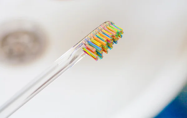 Tandenborstel hoofd tegen wastafel — Stockfoto