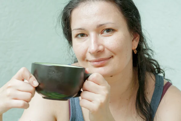 Woman smiling drinking tea front view — Stock Photo, Image