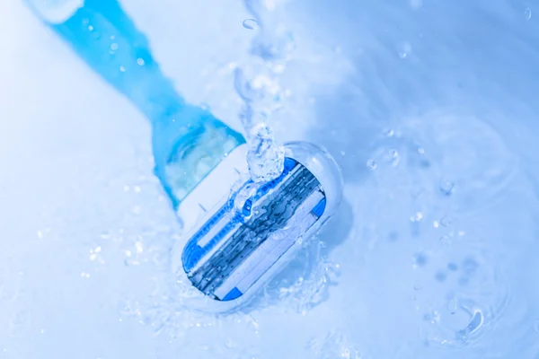 Razor close-up with water splash isolated on grey — Stock Photo, Image