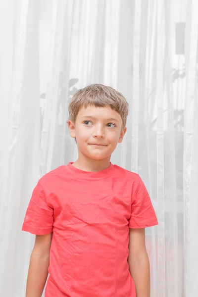 Blonde jongen in een rode shirt binnenshuis — Stockfoto