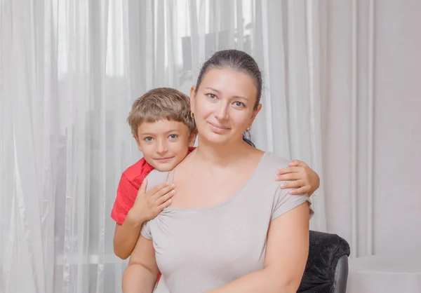 Mãe feliz com o filho no fundo claro — Fotografia de Stock