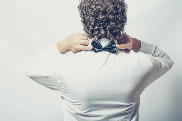 Bow tie on the back side. Strange or fun concept. Back view of an elegant young fashion man in tuxedo , toned image — Stock Photo, Image