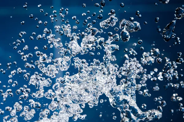 Niebieski rozchlapać krople wody z bliska strzelać — Zdjęcie stockowe