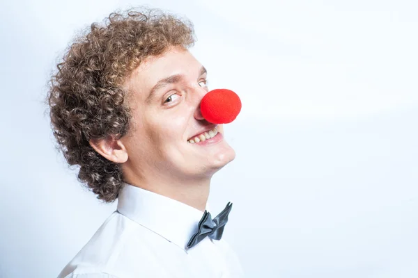 Jovem garanhão ou empresário com um nariz de palhaço vermelho. Tiro no estúdio. Cabeça e ombros . — Fotografia de Stock