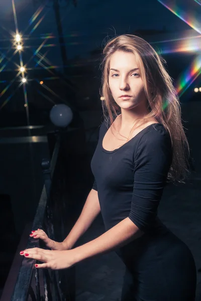 Beautiful lonely woman in the old house against city night light. — Stock Photo, Image