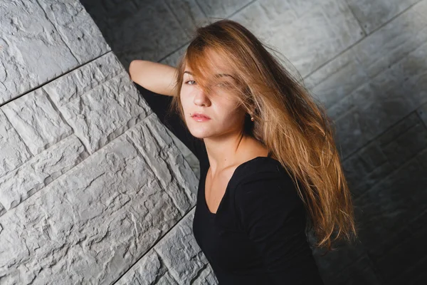 Kaukasische vrouw leunend op muur met gesloten ogen en hand onder ogen zien. — Stockfoto