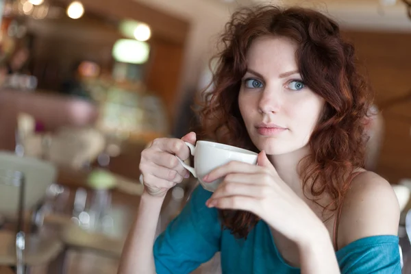 赤毛の女性と、cafee に座って一杯のコーヒーを保持 — ストック写真