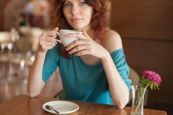 Mulheres ruivas sentadas no cafee e segurando uma xícara de café — Fotografia de Stock