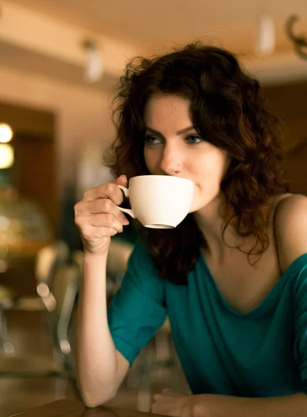 Zrzka ženy sedí cafee a drží šálek kávy — Stock fotografie