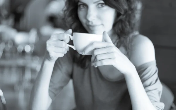 Redhead women sitting in the cafee and holding cup of coffee — Stock Photo, Image