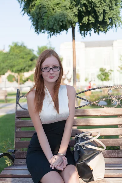 Style redhead girl sitting on the bench — Stock Photo, Image