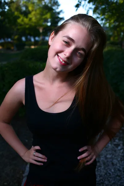 Vacker leende flicka poserar över gröna sommaren bakgrund — Stockfoto