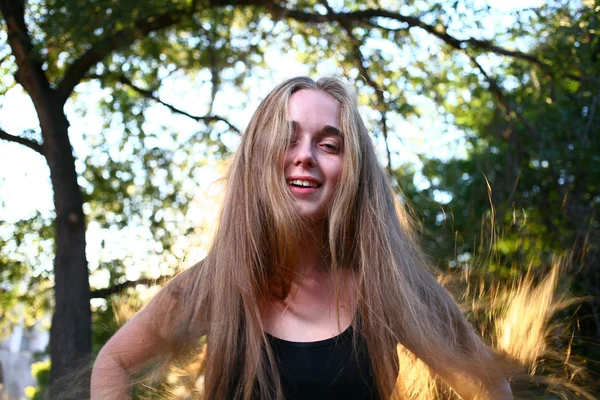 Menina sorridente bonita posando sobre fundo de verão verde — Fotografia de Stock