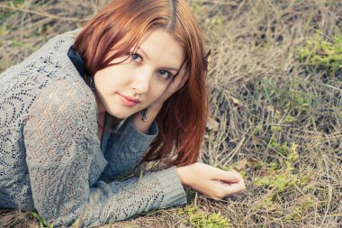 Kızıl saçlı kadınların sonbahar çim üzerinde yalan