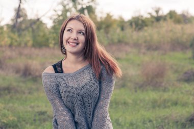 Kızıl saçlı sonbaharda açık havada gri kazak giyerdi.