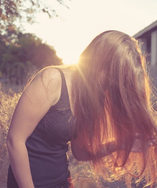 Junge Frau im Herbst bei Sonnenuntergang im Gegenlicht — Stockfoto