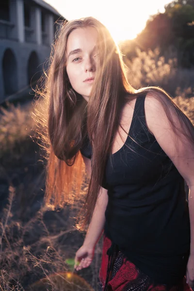 Jonge vrouw in de herfst bij zonsondergang terug licht — Stockfoto