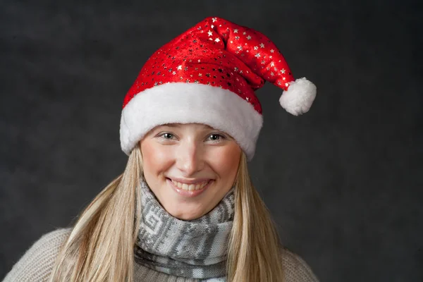 Pretty blond wearing christmas hat on dark background — Stock Photo, Image