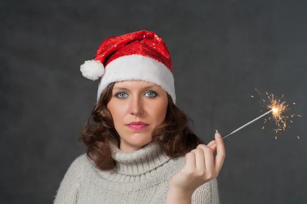 Cute girl in Santa hat holding sparklers — Stock Photo, Image