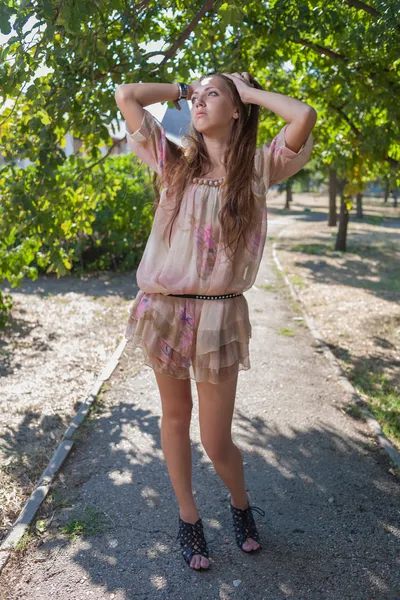 Krásná mladá žena s dlouhými vlasy v šatech venkovní — Stock fotografie