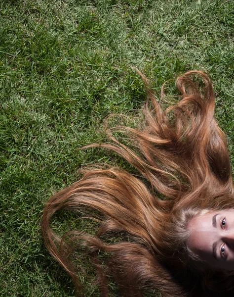 Linda joven hembra acostada en el campo de hierba en el parque por la noche — Foto de Stock