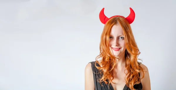 Redhead girl with red horns looks like pretty Devil — Stock Photo, Image