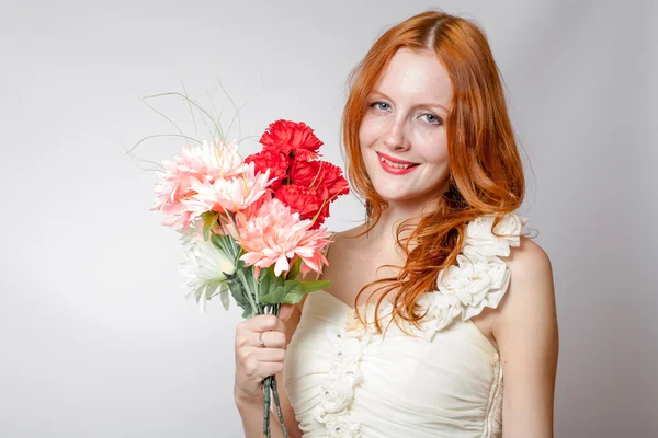Belle fille rousse avec des fleurs studio tourné — Photo