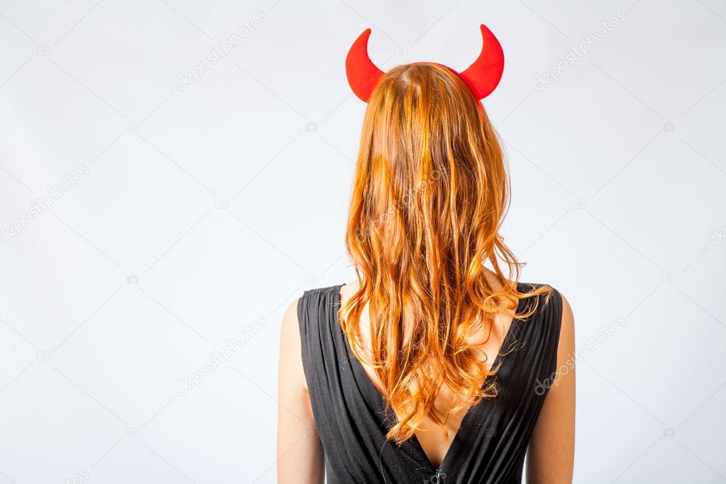 Redhead girl with red horns looks like pretty Devil