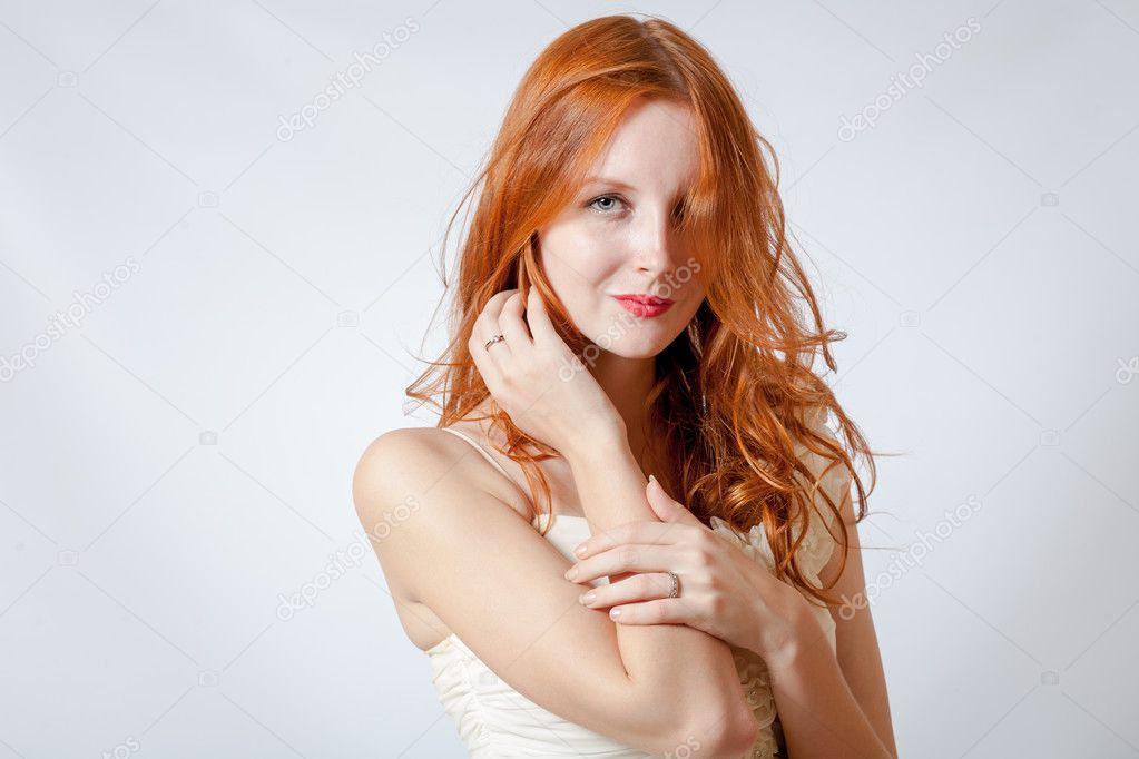 beauty shot of a young blue eyed woman with her red hair