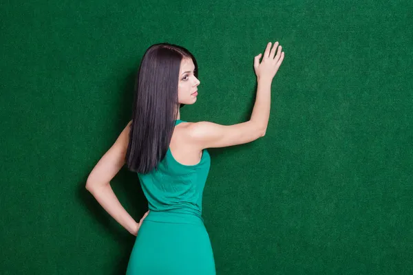 背面から緑の壁に対してブルネテ女性 — ストック写真