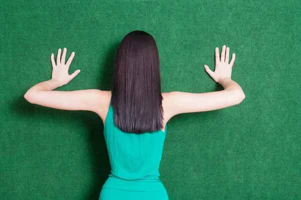 Morena senhora contra a parede verde de volta — Fotografia de Stock