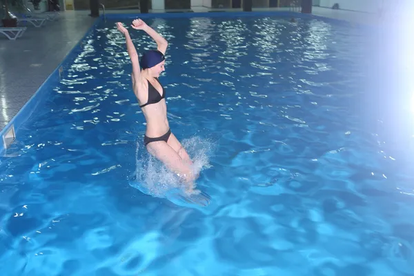 Jovem salto de mulher na piscina — Fotografia de Stock