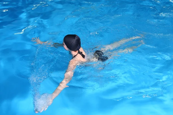 Fiatal nő úszni medencében — Stock Fotó