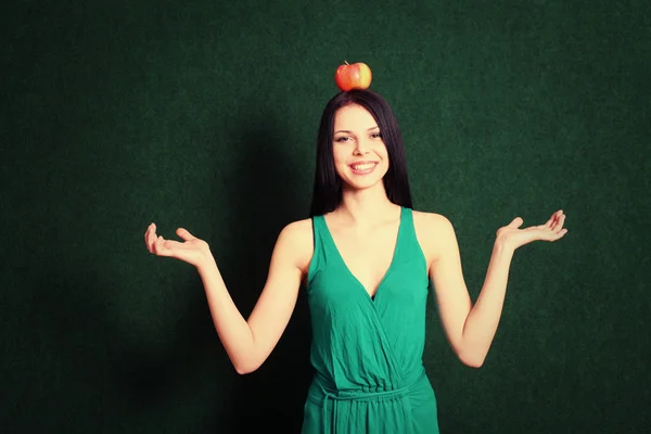 Young female with an apple on the her head — Stock Photo, Image