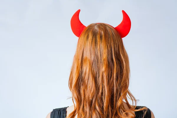 Närbild på en röd korthårig tjej med horn som en djävul — Stockfoto